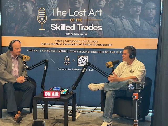 Andrew Brown interviewing a guest on The Lost Art of the Skilled Trades set with an ON AIR sign