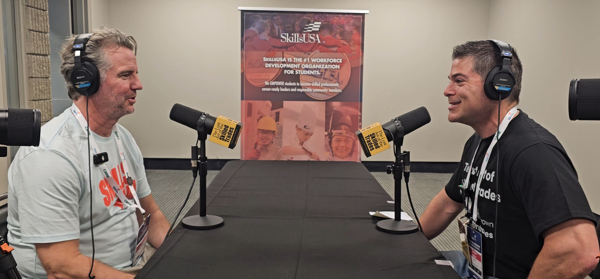 Andrew Brown recording a podcast interview in front of a SkillsUSA banner with branded microphones
